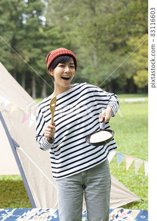 Young woman enjoying camping 83116603