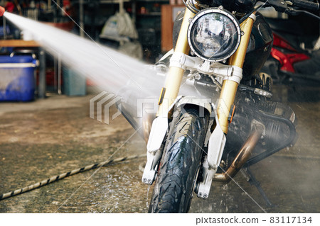 Man Rinsing Motorcycle 83117134