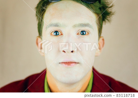 Guy with white makeup on face and green hair. 83118718