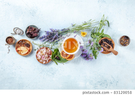 Organic tea. Herbs, flowers and fruit around a cup of tea, a flat lay, top shot 83120058