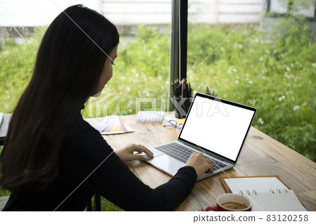 Side view young female working with computer laptop a home. 83120258