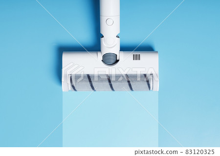 A vacuum cleaner nozzle with a clean stripe on a blue background. A vacuum cleaner nozzle with a clean stripe on a blue background. 83120325