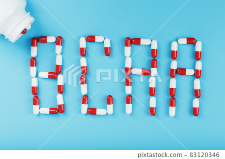 BCAA from red and white tablets from a white jar on a blue background 83120346