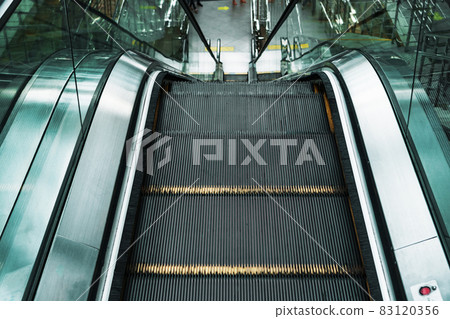 Escalator lifting steps in the waiting rooms of the station. Climbing the stairs Escalator lifting steps in the waiting rooms of the station. Climbing the stairs 83120356