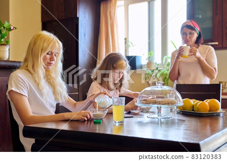 Family, girls, children eating at the table in the kitchen 83120383