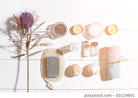 Spa set with sea salt, essential oil, soap and towel decorated with dry flower on white wooden background. Sun flare Spa set with sea salt, essential oil, soap and towel decorated with dry flower on white wooden background. Sun flare 83120691