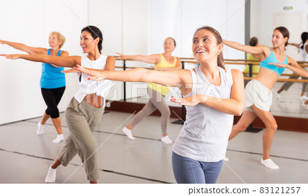 Women performing contemporary dance in training room 83121257