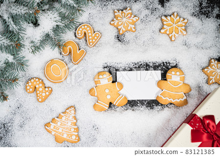Christmas background with gingerbread on winter snow. Holiday mood card. Top view, copy space. Family traditions, DIY, celebration concept. Festive background with homemade gingerbread cookies. Christmas background with gingerbread on winter snow. Holiday mood card. Top view, copy space. Family traditions, DIY, celebration concept. Festive background with homemade gingerbread cookies. 83121385