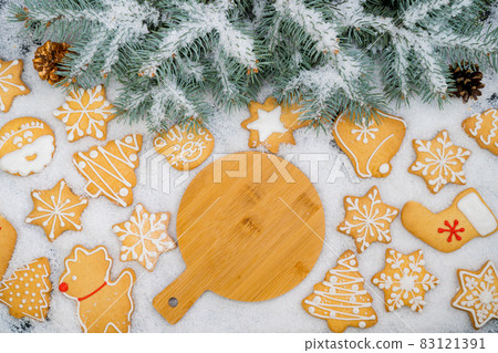 Pattern of gingerbread cookies in different shapes on a snow surface. Top view. Pattern of gingerbread cookies in different shapes on a snow surface. Top view. 83121391