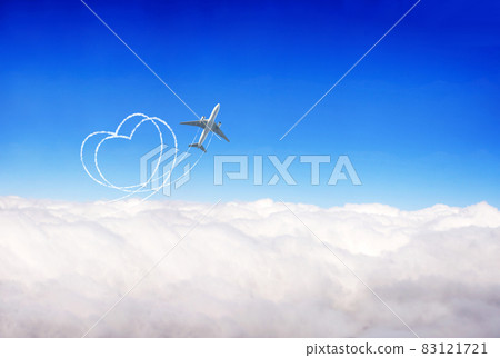 Aircraft draw a heart in the sky. Plane flies over clouds against  blue sky background 83121721