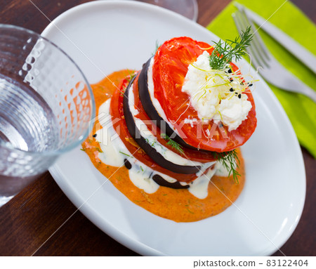 Fried eggplant pyramid with tomatoes on spicy sauce Fried eggplant pyramid with tomatoes on spicy sauce 83122404