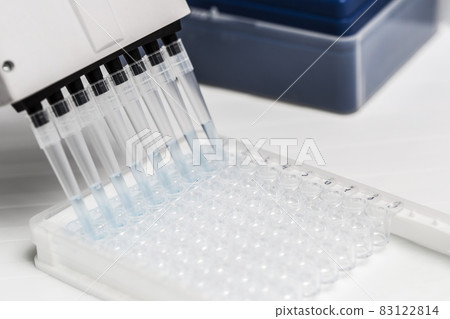 Pipette depositing samples into a 96 well micro-plate 83122814