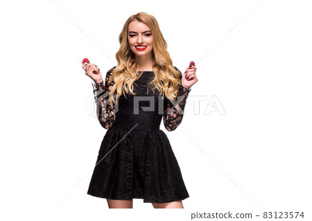 Beautiful blonde in a black dress with casino chips in hands isolated on a white background Beautiful blonde in a black dress with casino chips in hands isolated on a white background 83123574