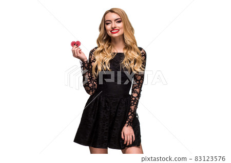 Beautiful blonde in a black dress with casino chips in hands isolated on a white background Beautiful blonde in a black dress with casino chips in hands isolated on a white background 83123576