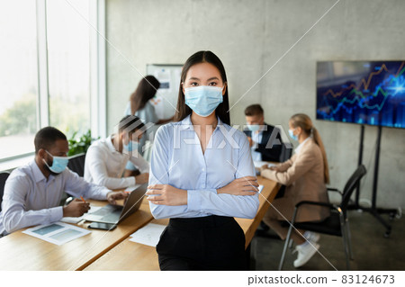 Covid-19 And Entrepreneurship. Portrait of confident young asian businesswoman in medical mask 83124673