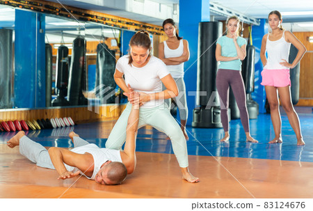 Hispanic female practicing self defence techniques with coach 83124676