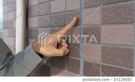 Workers inspecting the outer wall. Deterioration of joints. 83126083