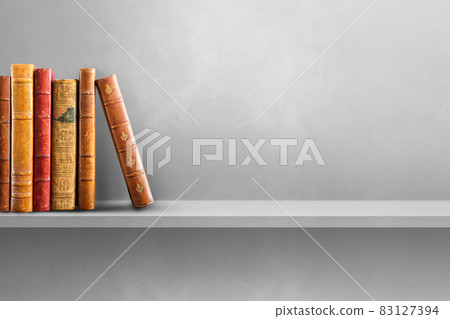 Row of old books on grey shelf. Horizontal background 83127394