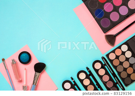 Make up essentials. Set of professional make up brushes, creams and shadows in jars on blue background. Make up essentials. Set of professional make up brushes, creams and shadows in jars on blue background. 83129156