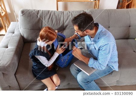 Top view image of father and daughter, pupil packing school backpack together. School preparation Top view image of father and daughter, pupil packing school backpack together. School preparation 83130090