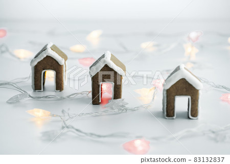 Gingerbread houses for a cup and Christmas lights. Christmas baked goods Gingerbread houses for a cup and Christmas lights. Christmas baked goods 83132837