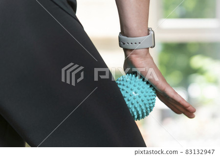 Woman using massage tool for myofascial therapy on thigh muscles. Roller for physiotherapy. Woman using massage tool for myofascial therapy on thigh muscles. Roller for physiotherapy. 83132947