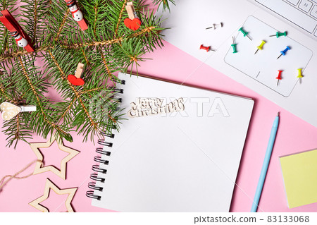 Christmas composition of open blank notepad, fir branches and laptop on pink paper background 83133068