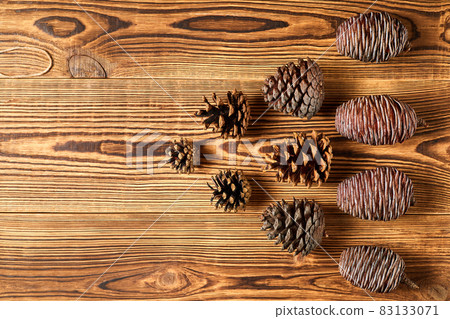 Fir cones on brown wooden background with copy space 83133071