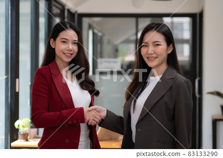 Two confident business asian woman shaking hands during looking at camera in the office, success, dealing, greeting and partner concept Two confident business asian woman shaking hands during looking at camera in the office, success, dealing, greeting and partner concept 83133290