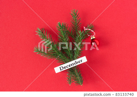 Calendar winter month December and christmas tree on red background. Top view Flat lay. Minimal Holiday concept. Template for your design, greeting card 83133740