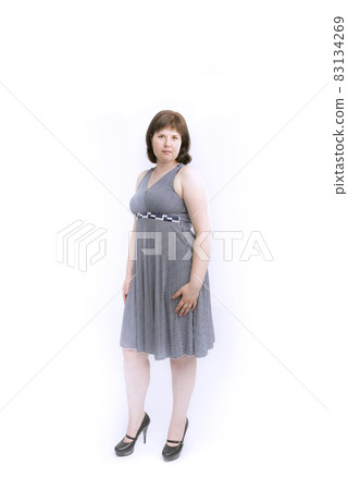 Plus size model in gray medium-length with heels. Isolated on white background. 83134269