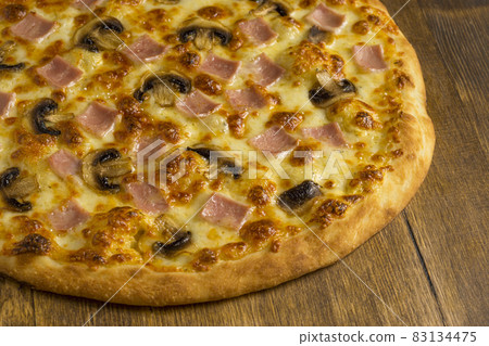 Ruddy mushroom pizza baked with mushrooms, ham and cheese Ruddy mushroom pizza baked with mushrooms, ham and cheese 83134475