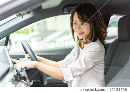 Young woman operating a car navigation system 83135706