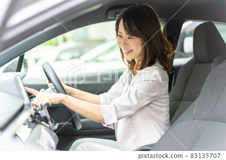 Young woman operating a car navigation system 83135707