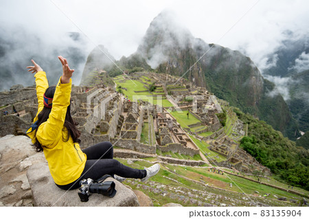 Asian woman traveler raising hand at Machu Picchu Asian woman traveler raising hand at Machu Picchu 83135904