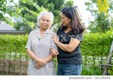 Asian elderly woman with caregiver daugther walking with happy in nature park. Asian elderly woman with caregiver daugther walking with happy in nature park. 83136845