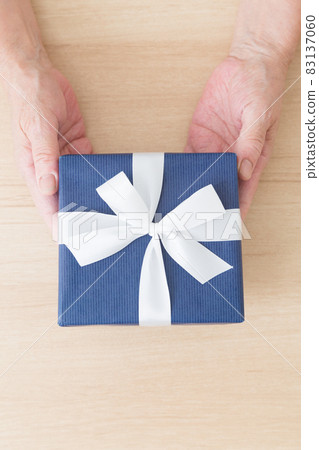 Hands of seniors with gift boxes 83137060