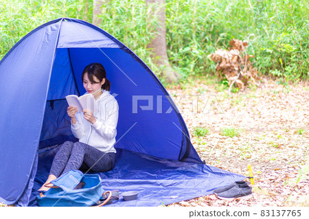 Young woman enjoying solo camp 83137765