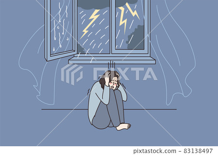 Anxious woman feel scared of thunderstorm at home  83138497