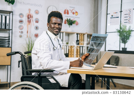 African medical worker in wheelchair checking x ray scan African medical worker in wheelchair checking x ray scan 83138642