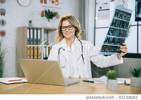 Female doctor explaining x ray scan at office, while having video call with patient 83138682