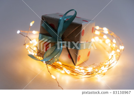 A gift with a glowing garland. Christmas Concept A gift with a glowing garland. Christmas Concept 83138967