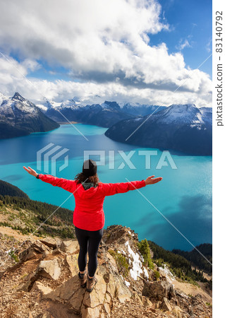 Adventurous Caucasian Woman hiking on top of a Canadian mountain. Adventurous Caucasian Woman hiking on top of a Canadian mountain. 83140792