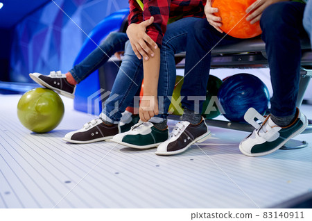 Group of children put on bowling shoes on bench Group of children put on bowling shoes on bench 83140911
