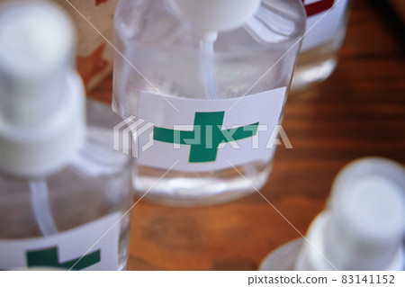 Alcohol antiseptics with the green cross logo on wooden table. Alcohol antiseptics with the green cross logo on wooden table. 83141152