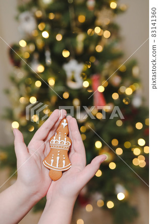 Decorating Christmas tree, holding Christmas toy in a hand. Holiday, Christmas and New Year family celebration concept 83141360