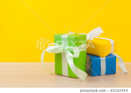 Gifts with ribbons on bright yellow background 83142454