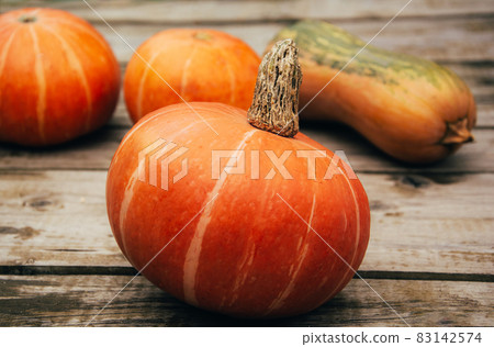 Autumn orange pumpkins on wooden planks at farm. Thanksgiving and halloween season. Harvesting, colors of autumn 83142574