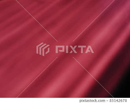 Diagonal rays of light on a red pink or burgundy background. Blurred abstract background light effect and leaks. Side surface illumination. Parallel and asymmetric lines, stripes of light at an angle. 83142678