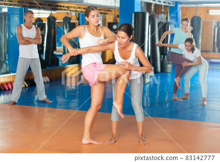 Young woman training knee strike Young woman training knee strike 83142777